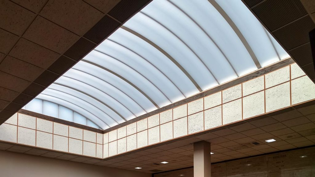 A bright, modern interior skylight with a curved, translucent roof allows soft, natural light to fill the space, creating an open and inviting atmosphere.