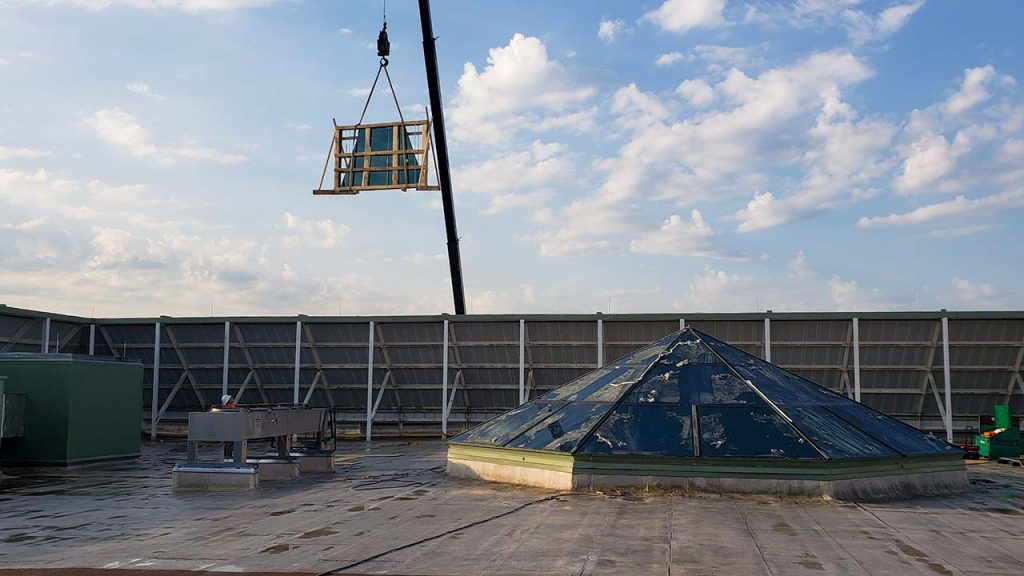 An image of the crane lifting a crate of glass to the roof.