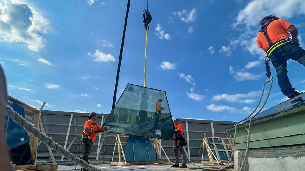 A new glass unit is lifted by the crane.