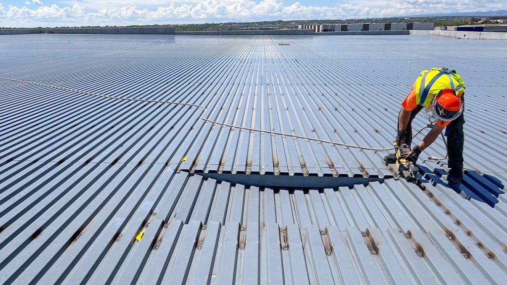 An image of a tech cutting an opening in the roof.