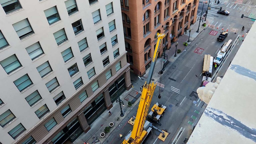 The crane is setup and ready to lift material to the roof.