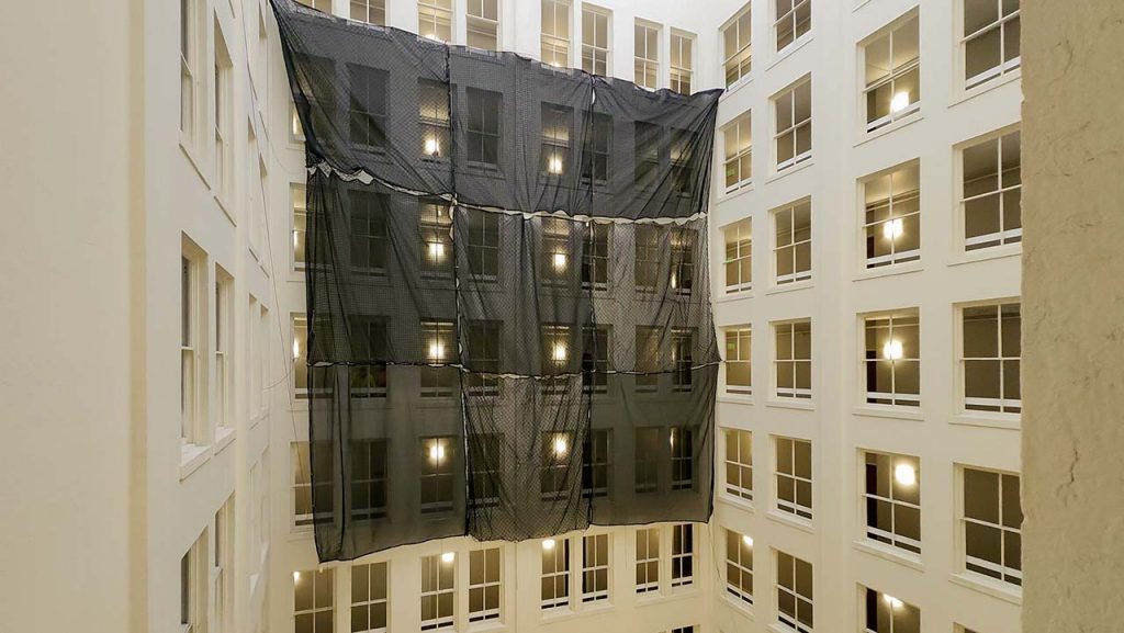 Several net tarps connected together and hanging in the atrium.