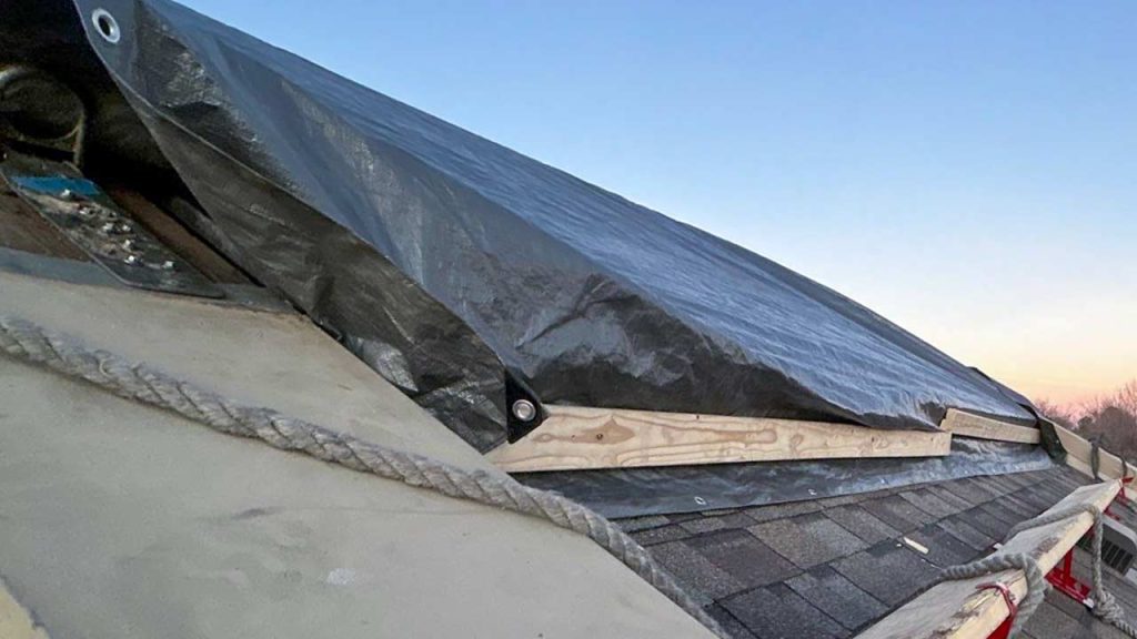 A tarp covers one side of the skylight awaiting resumption of work.