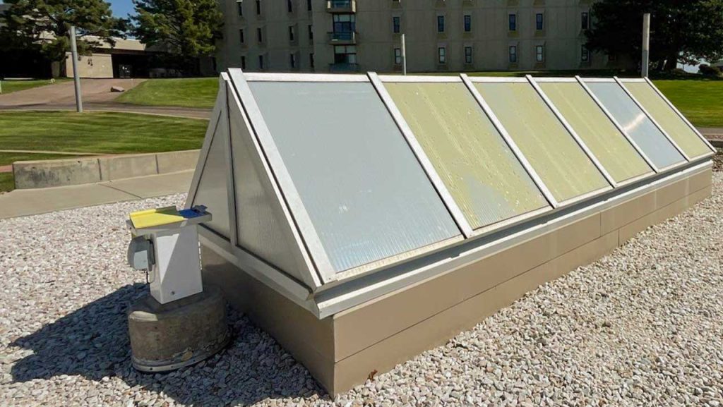 An image of a ridge skylight with yellowed and damaged panels.