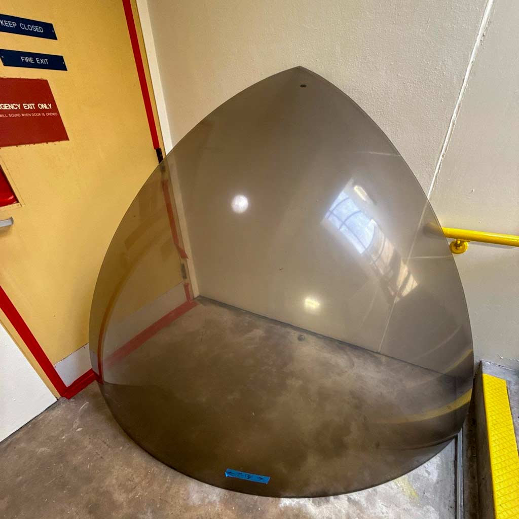 A large polycarbonate panel lying on the floor, featuring a sleek design and a transparent appearance.