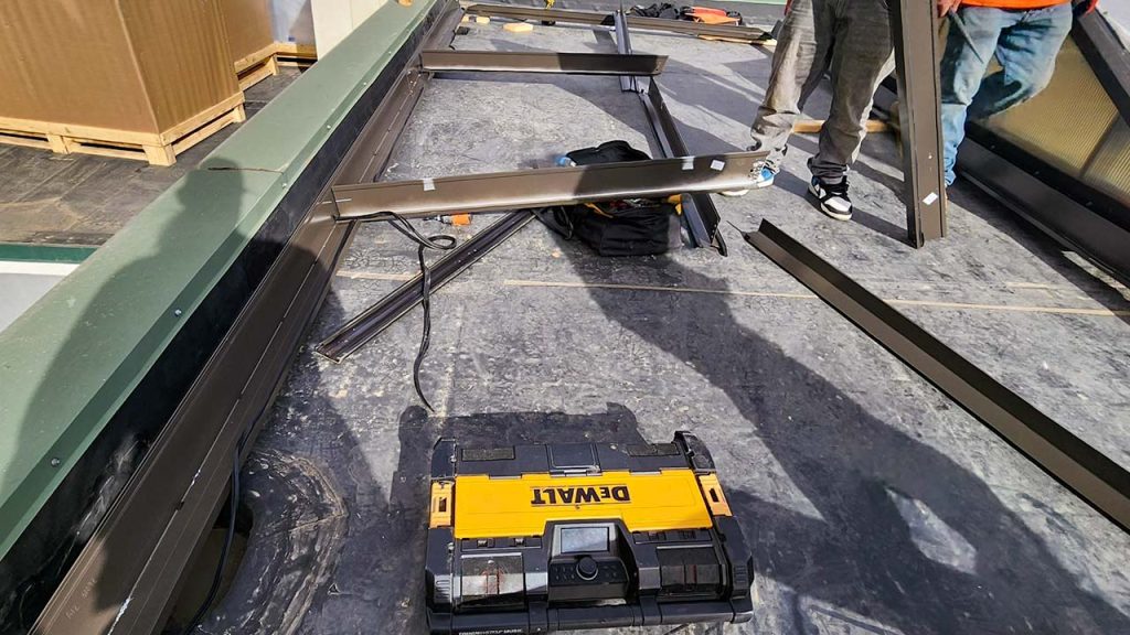 Two technicians are assembling the new skylight frame.