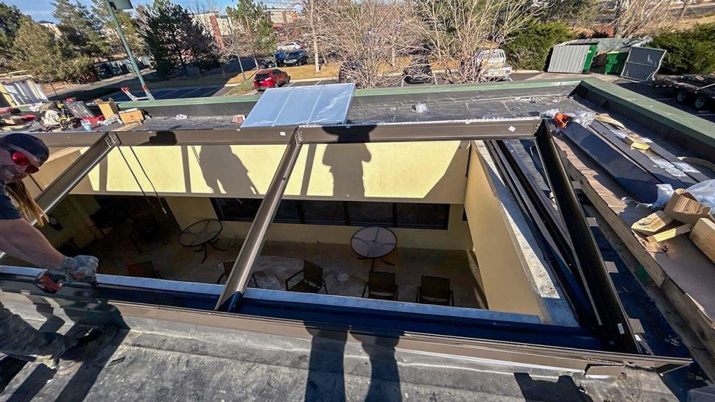 The assembled screen is being mounted over the skylight opening.