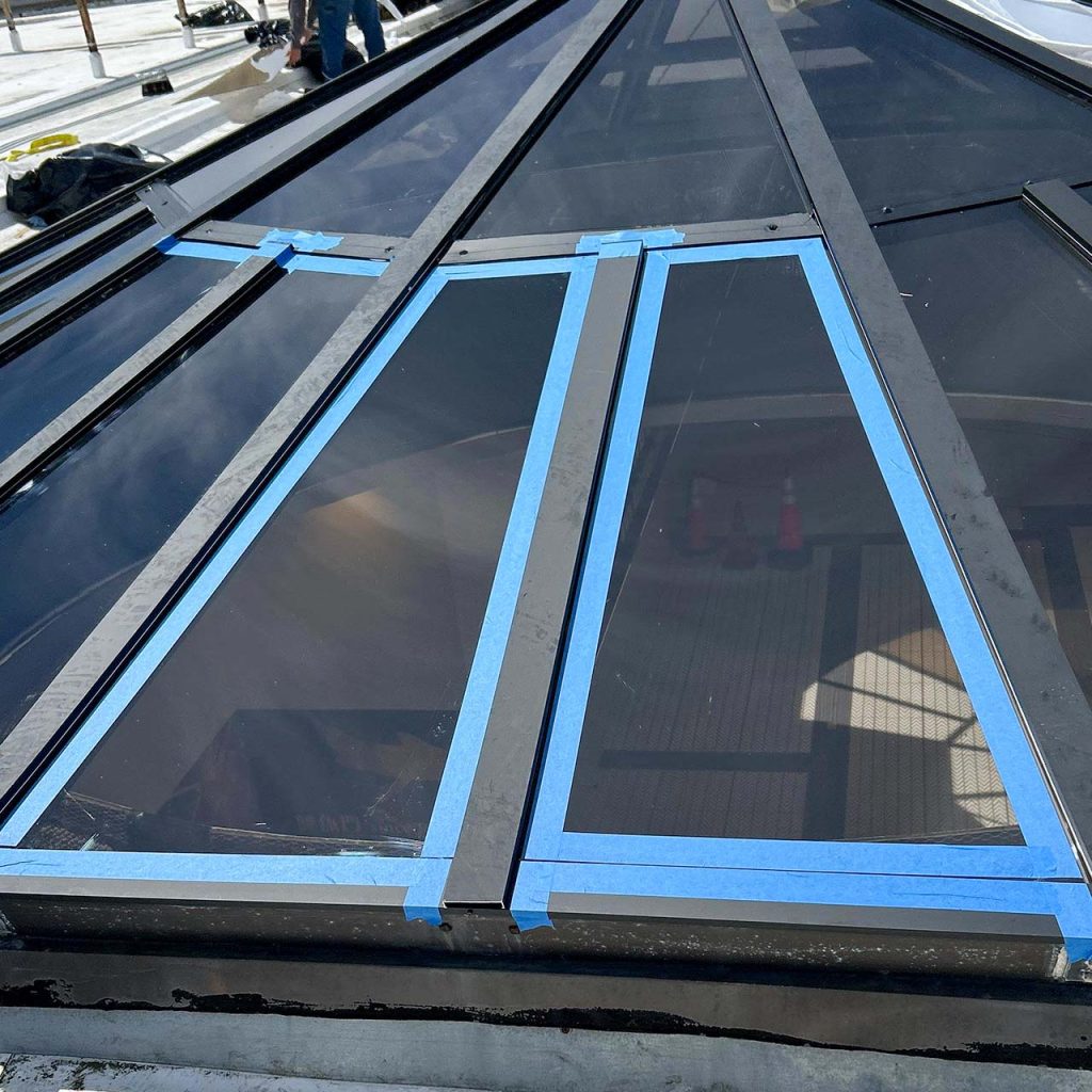 Two panrls have been installed and the perimeters masked for applying silicone sealant.