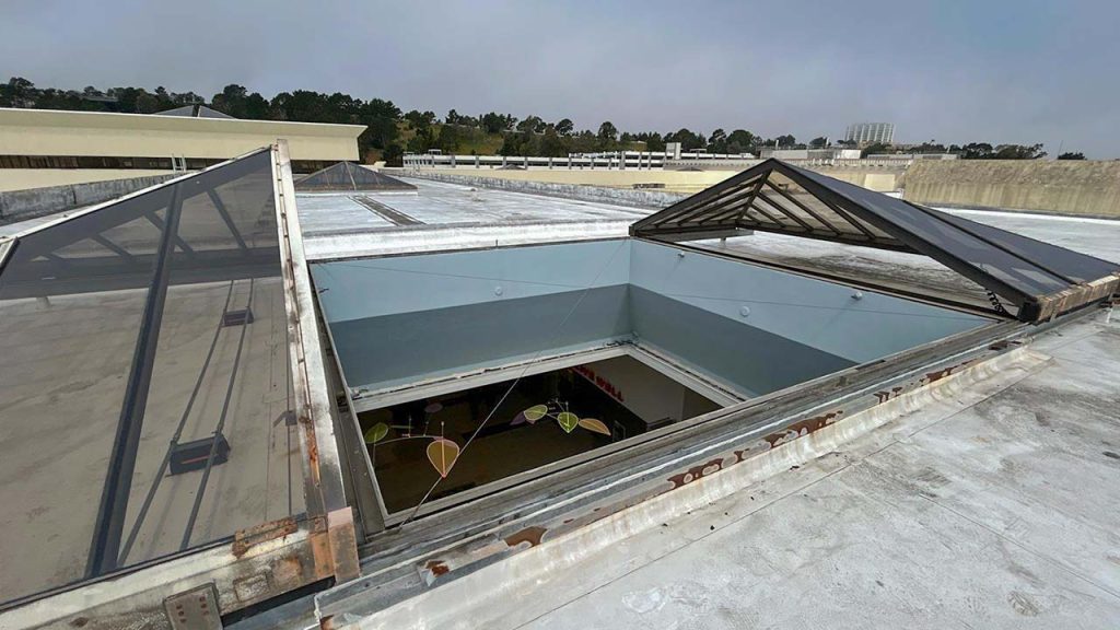 A roof with an operableglass pyramid skylight,on the roof is fully open.