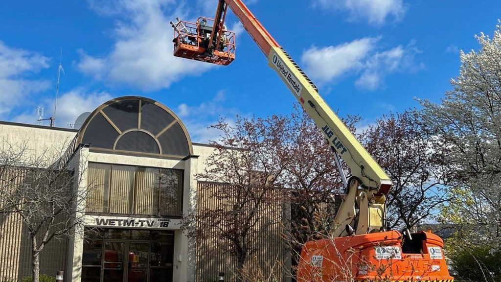 Technicians on a manlift maneuvering towards a position above the barrel vault skylight.