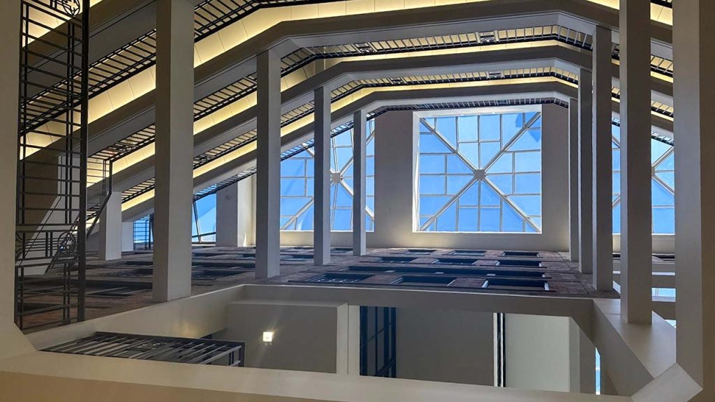 Restored Pyramid Skylights El Paso Centre Building. Modern atrium interior with geometric lines, large grid windows, and skylights. The space exudes an airy, architectural elegance with natural light.