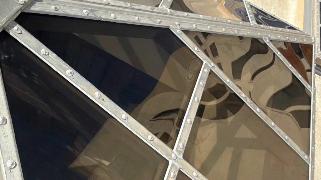 Restored Pyramid Skylights El Paso Centre Building. Close-up of a geometric polycarvonate and metal skylight section reflecting distorted shapes and shadows, creating an abstract, modern, and industrial feel.