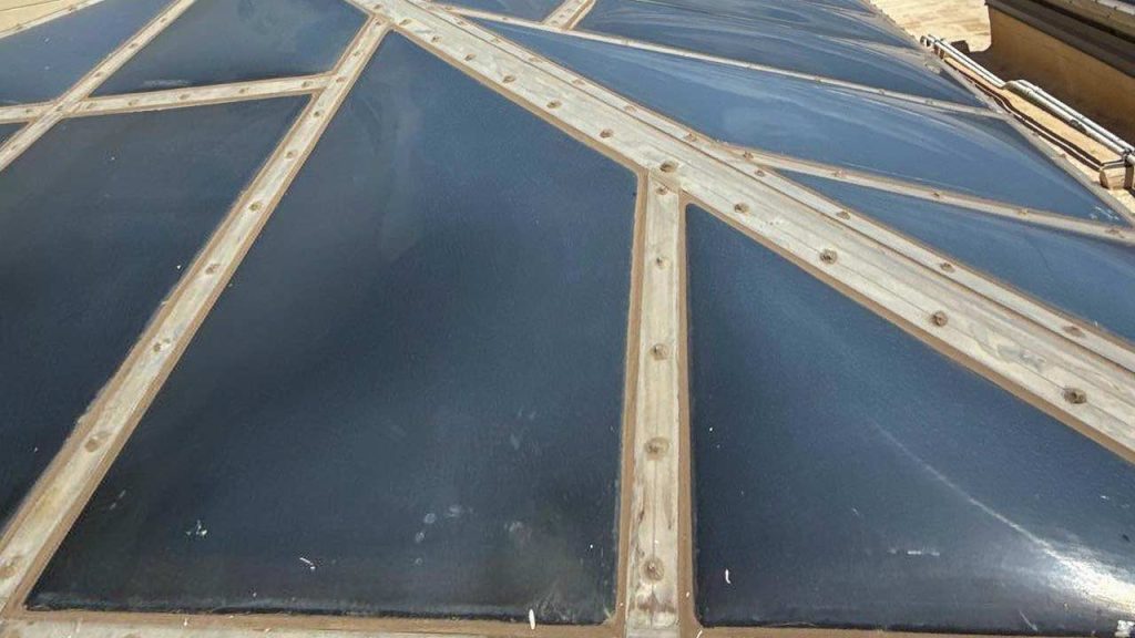 Geometric skylight with triangular plastic panels framed in metal, creating a futuristic pattern. The image conveys modern architecture and innovation.