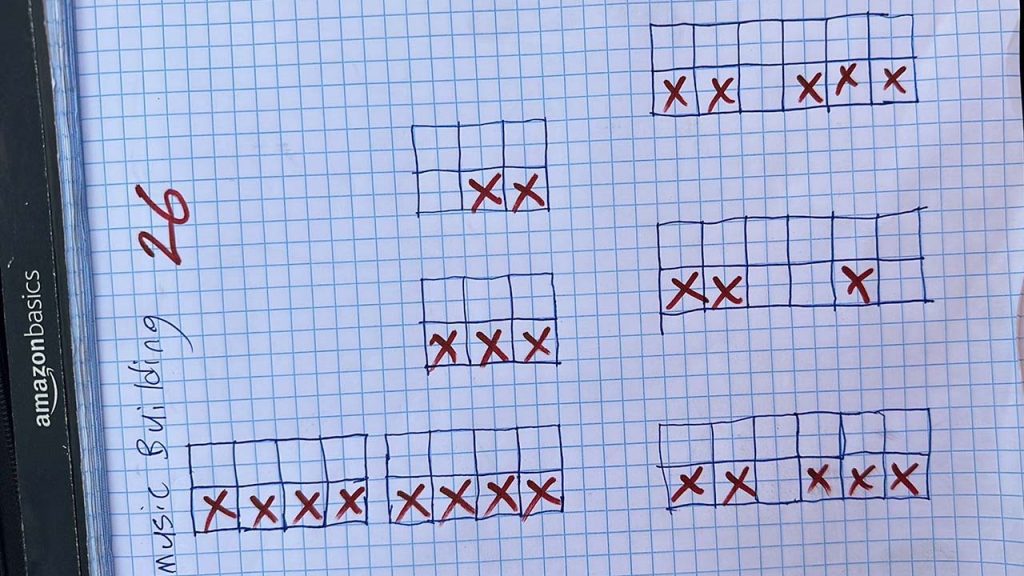 Hand-drawn on graph paper, several rectangular grids contain red "X" marks, suggesting a seating or layout plan. "Music Building 26" is noted.