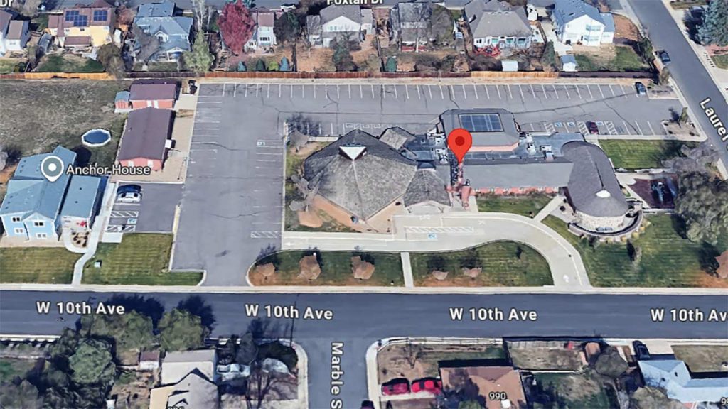 Aerial view of the Lutheran Church of Hope featuring a circular building with a conical roof, parking lot, and nearby residential homes. A red location pin is visible.