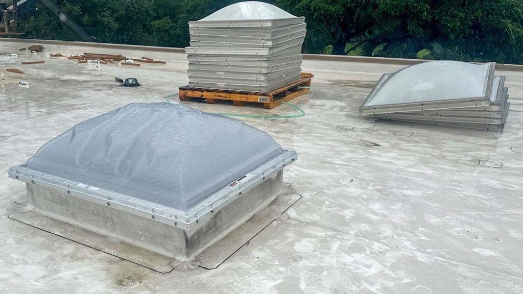 Translucent commercial dome skylight installed on a flat roof during a Velux Dynamic Dome retrofit project.