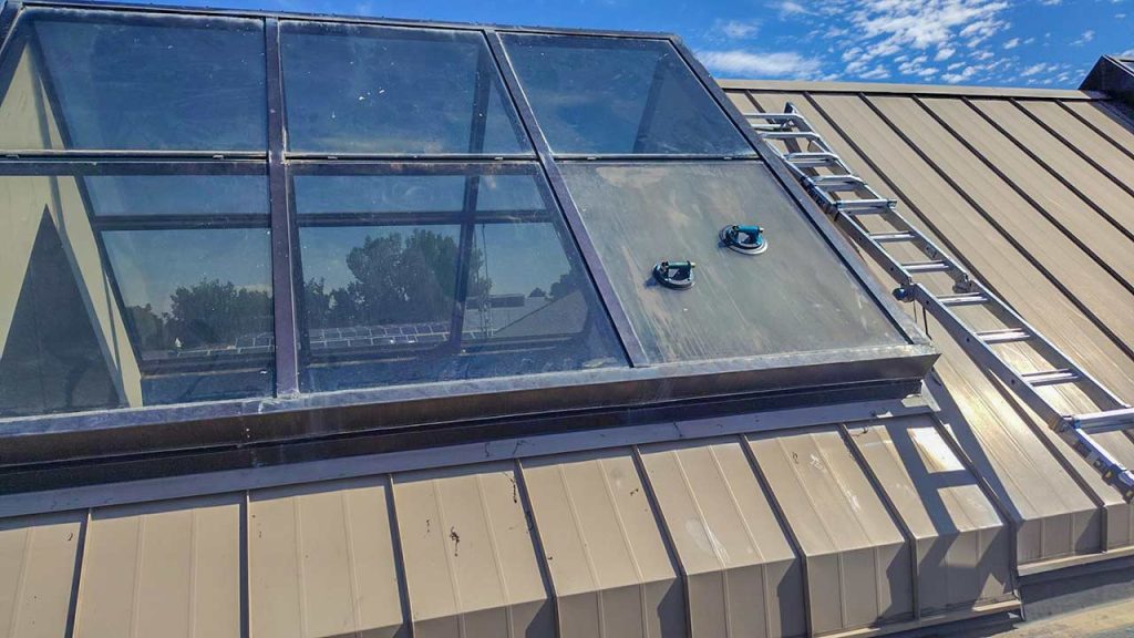 Commercial ridge glass skylight installation on a metal roof at an elementary school