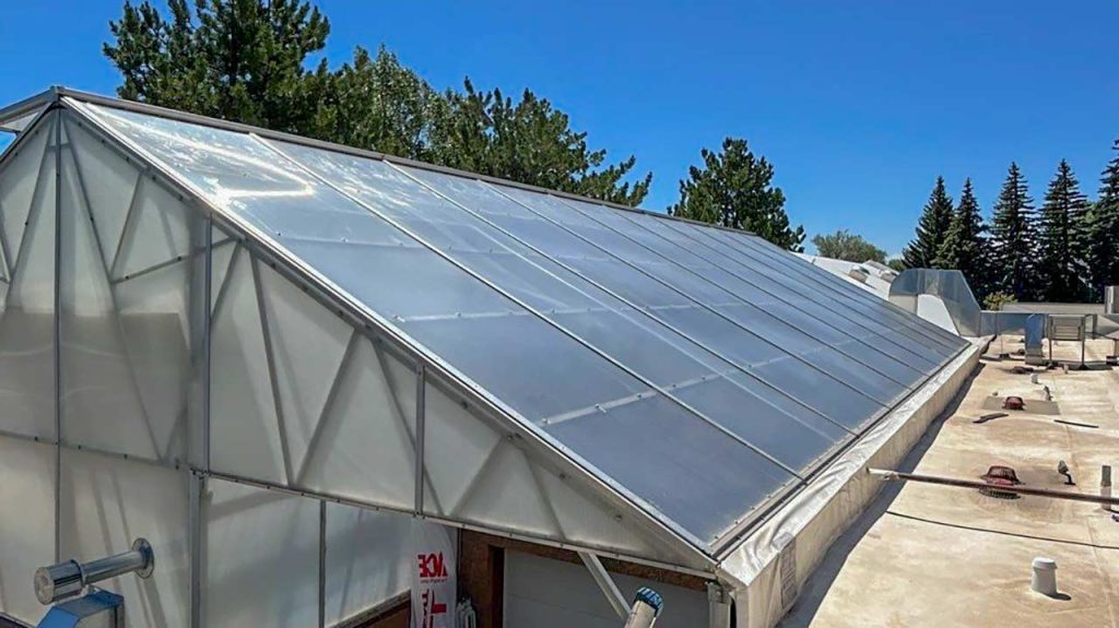 Commercial skylight wet seal repair on an angled metal frame glass structure at Ace Hardware in Laramie