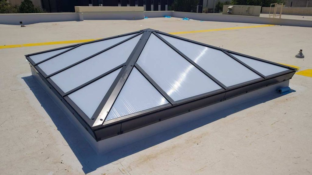 Newly installed commercial pyramid skylight replacement on the flat roof of the LCCC Crossroads Building