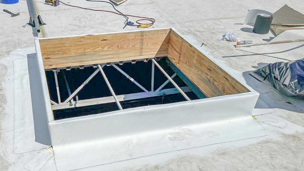 Rooftop view of a newly constructed commercial skylight curb to skylight installation