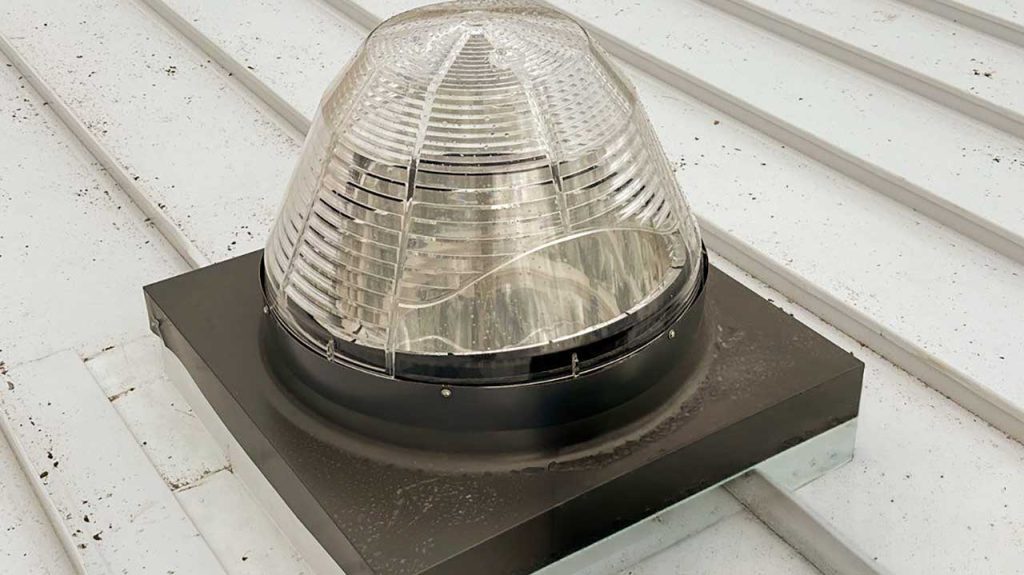 Velux TCC 022 tubular skylight dome installed on a corrugated metal roof