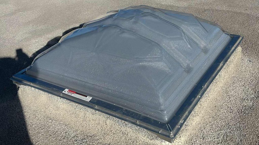 Velux Dynamic Dome skylight replacement installed on a gravel roof curb at Fox Hill Apartments